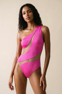 Front view of the Room 24 Freya fuchsia one-piece swimsuit with an asymmetric shoulder and sweeping illusion-mesh cut-outs.