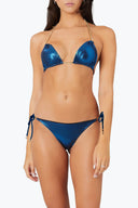 Woman wearing metallic blue string bikini with gold chain straps